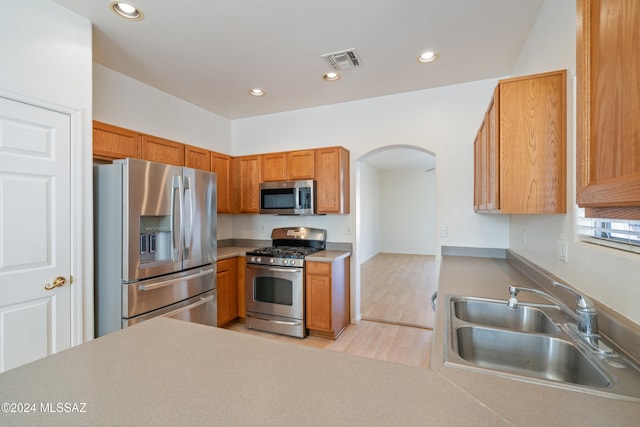 kitchen featuring stainless steel appliances, light hardwood / wood-style floors, and sink