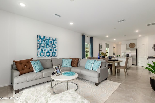 living room featuring sink and light tile patterned flooring