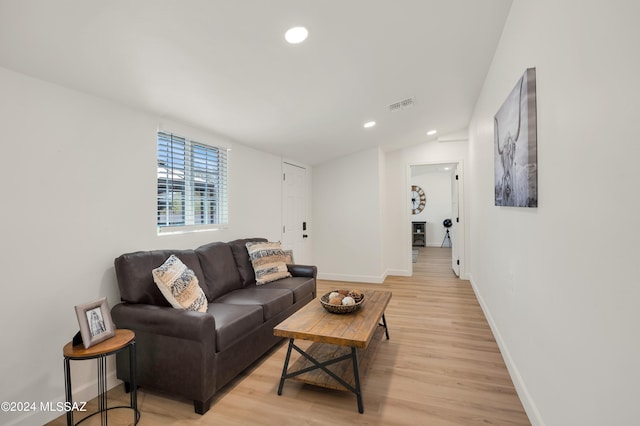 living room with vaulted ceiling and light hardwood / wood-style floors