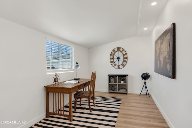 office with lofted ceiling and light hardwood / wood-style floors