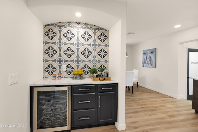 bar featuring beverage cooler and light wood-type flooring