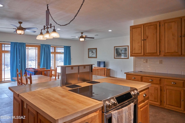 kitchen with ceiling fan, backsplash, stainless steel range with electric cooktop, and light tile flooring