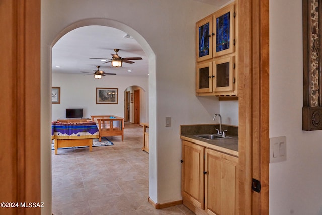 kitchen featuring light tile floors, ceiling fan, and sink