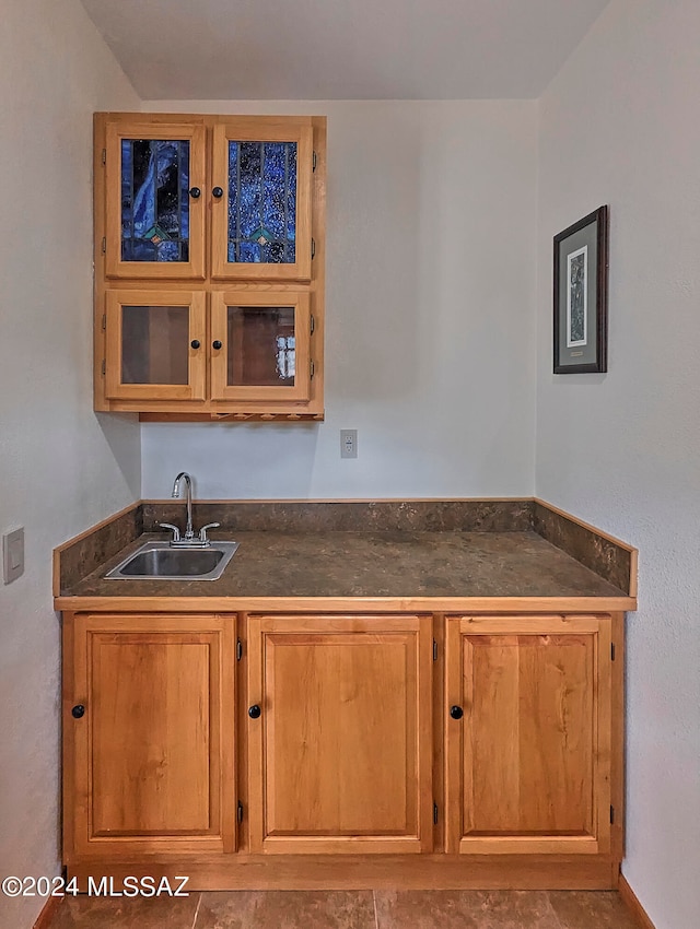 kitchen featuring sink and dark tile flooring