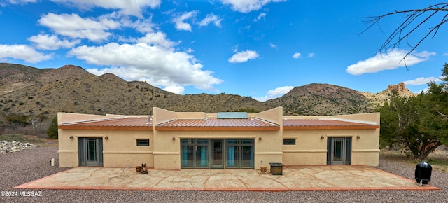 back of property with a patio, a mountain view, and french doors