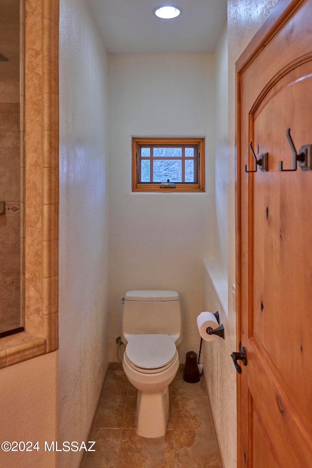 bathroom with toilet and tile flooring