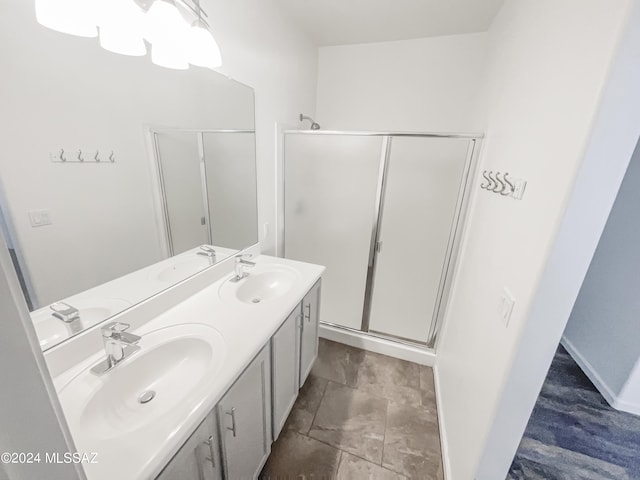 bathroom with a stall shower and a sink