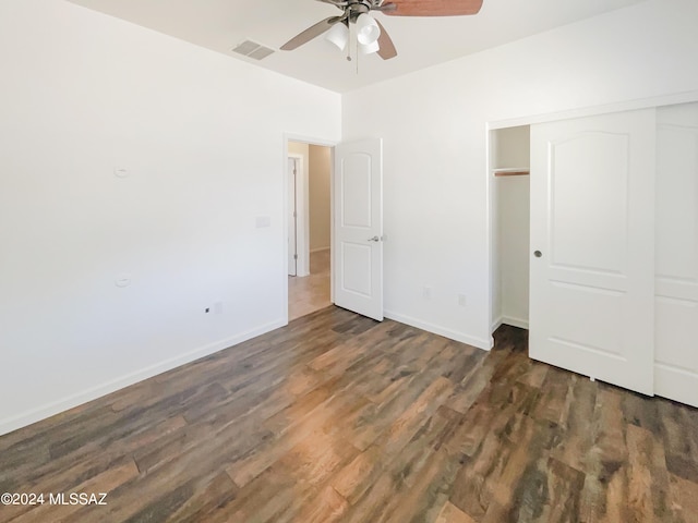 unfurnished bedroom with wood finished floors, a ceiling fan, visible vents, baseboards, and a closet