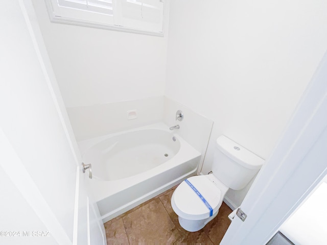 bathroom featuring a garden tub and toilet