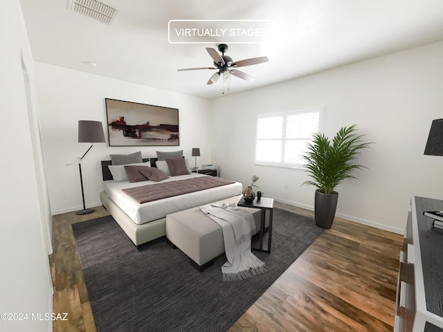 bedroom with ceiling fan, wood finished floors, visible vents, and baseboards