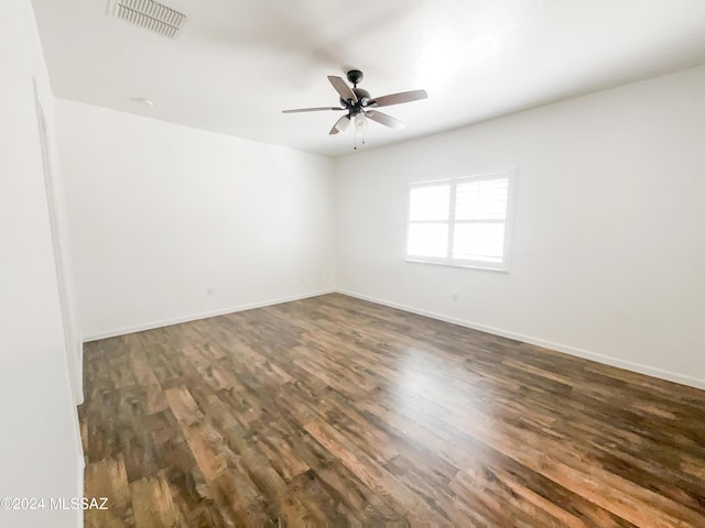 empty room featuring visible vents, ceiling fan, baseboards, and wood finished floors