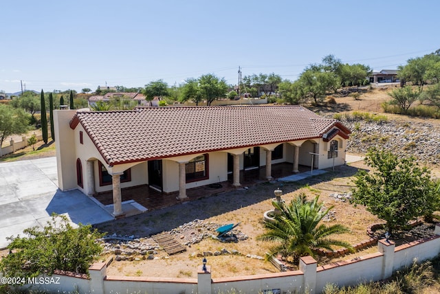 view of front of house with a chimney, a tile roof, and stucco siding
