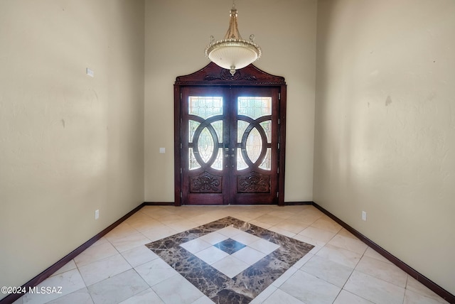 foyer entrance with light tile patterned flooring and french doors