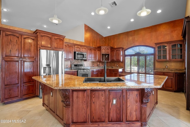 kitchen with a large island with sink, sink, hanging light fixtures, high vaulted ceiling, and stainless steel appliances