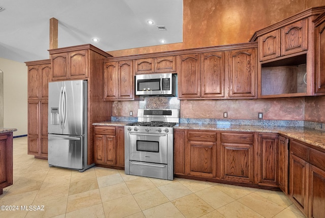 kitchen featuring light stone countertops, stainless steel appliances, and tasteful backsplash