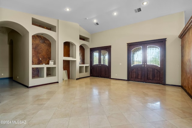 foyer featuring vaulted ceiling, light tile patterned flooring, and french doors