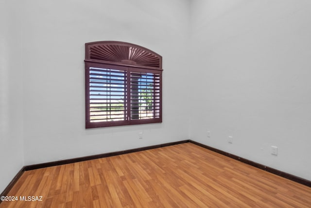 unfurnished room featuring baseboards and wood finished floors