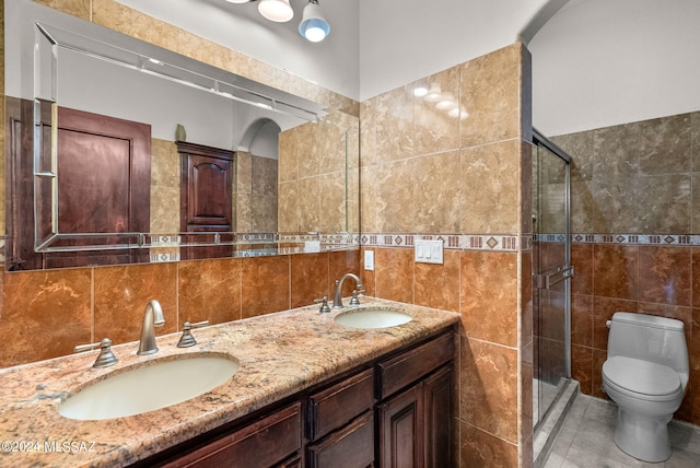 bathroom featuring tile walls, a shower with door, and toilet