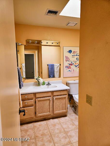 bathroom with tile patterned flooring, vanity, and toilet