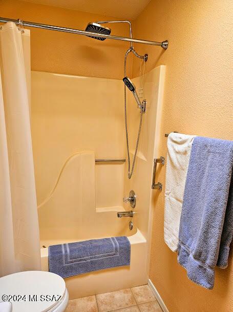 bathroom featuring tile patterned floors, toilet, and shower / tub combo