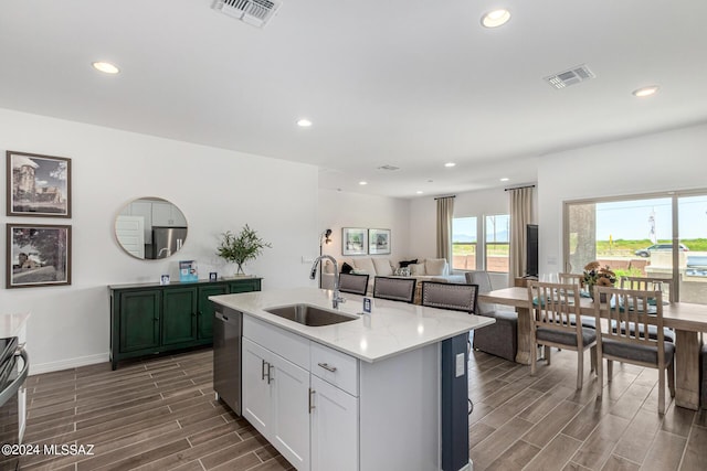 kitchen featuring a sink, visible vents, wood finish floors, and dishwasher