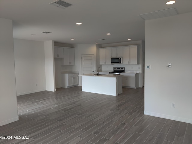 kitchen with visible vents, wood tiled floor, appliances with stainless steel finishes, white cabinetry, and a sink