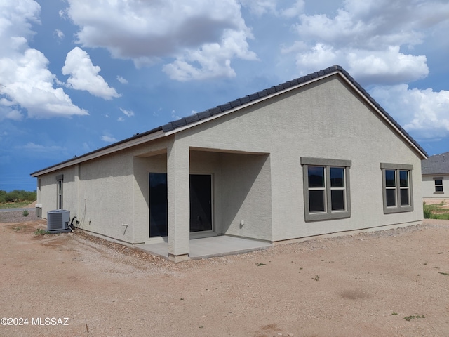 back of property featuring stucco siding, cooling unit, and a patio area