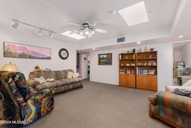 carpeted living room with ceiling fan, a skylight, and rail lighting