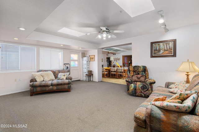 carpeted living room featuring ceiling fan, a skylight, and rail lighting