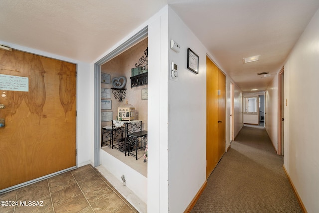 hallway featuring tile flooring and a textured ceiling