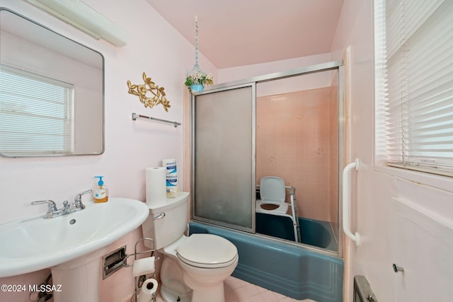 full bathroom with tile floors, sink, bath / shower combo with glass door, and toilet