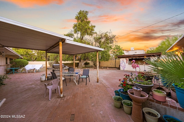 patio terrace at dusk featuring area for grilling