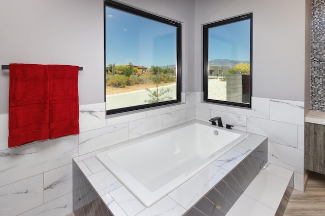 bathroom featuring a relaxing tiled bath