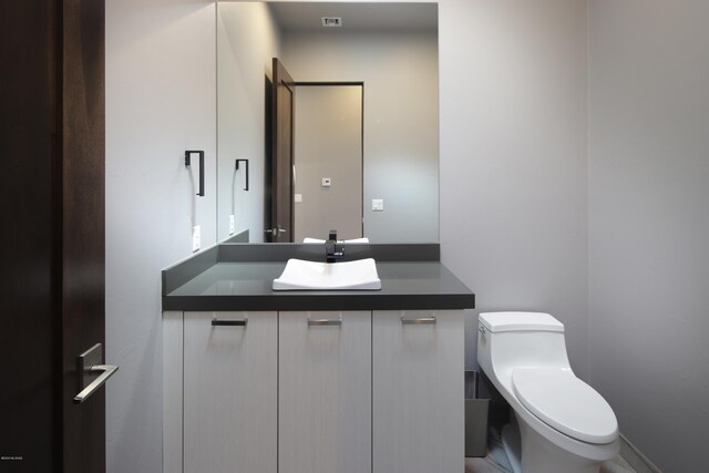 bathroom with vanity with extensive cabinet space and toilet