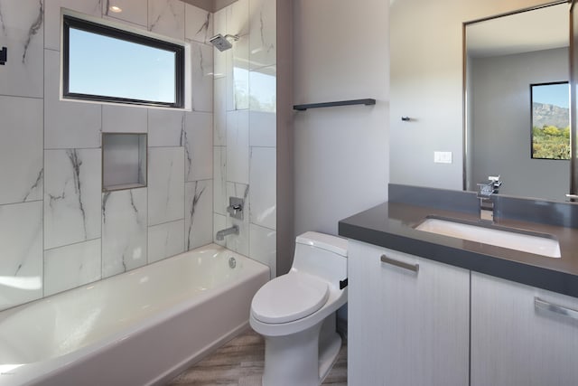 full bathroom featuring tiled shower / bath combo, toilet, and vanity