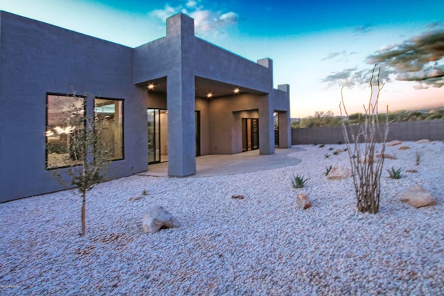 back house at dusk with a patio