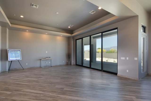 unfurnished room featuring dark hardwood / wood-style floors and a tray ceiling