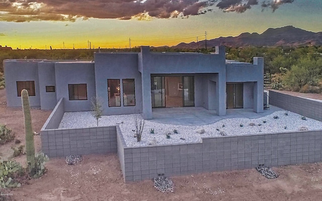 view of front of home with a patio and a mountain view