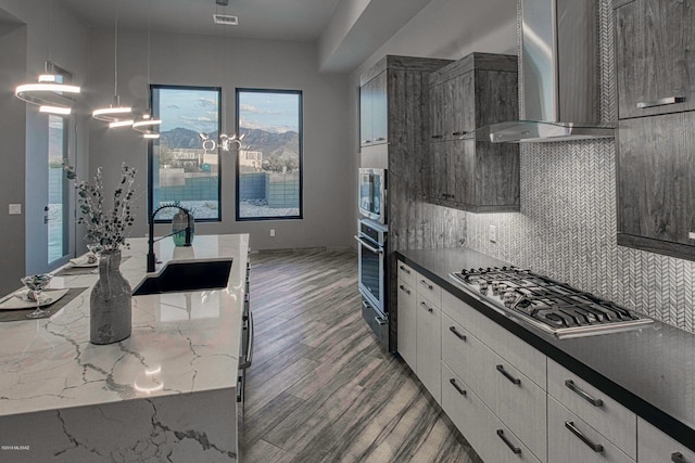 kitchen featuring wall chimney exhaust hood, hardwood / wood-style floors, tasteful backsplash, and white cabinets