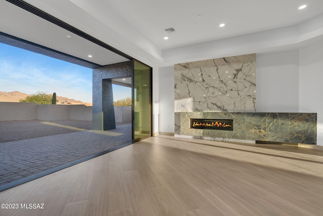 unfurnished living room featuring wood-type flooring, tile walls, and a fireplace