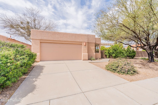 pueblo revival-style home featuring a garage