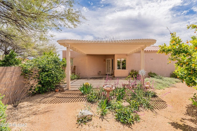 rear view of house featuring a pergola and a patio