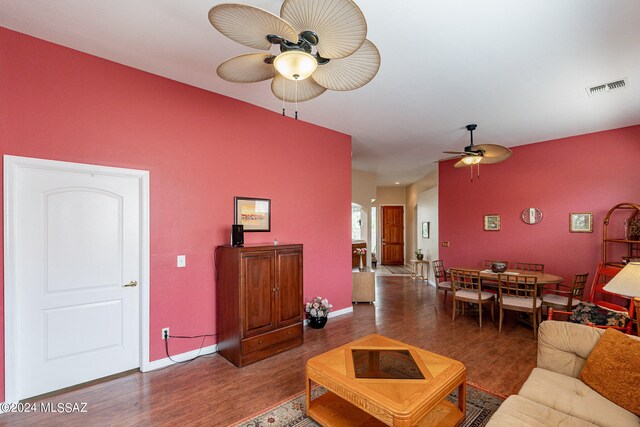 living room featuring ceiling fan and dark wood-type flooring