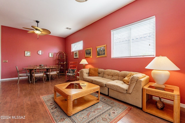 living room featuring dark hardwood / wood-style flooring, ceiling fan, and a healthy amount of sunlight