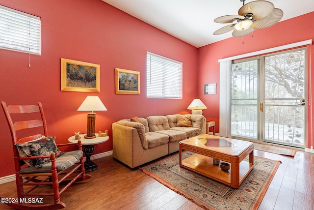 living room with ceiling fan and dark wood-type flooring