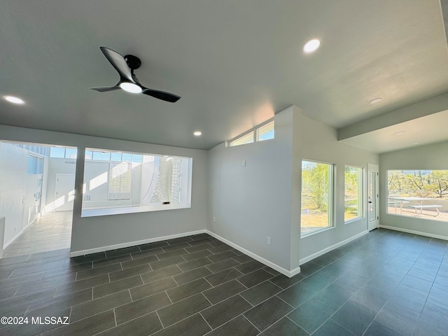 unfurnished room featuring dark tile patterned flooring, ceiling fan, and vaulted ceiling