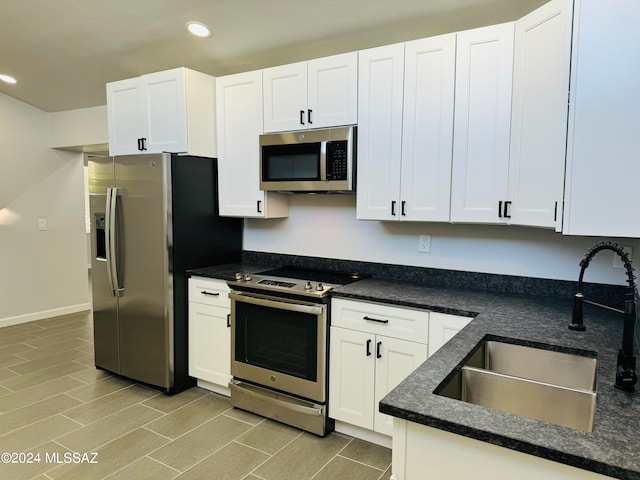 kitchen featuring sink, appliances with stainless steel finishes, and white cabinets