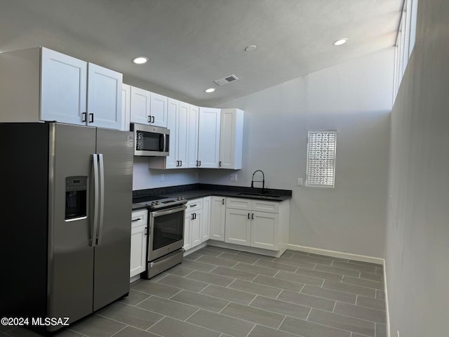 kitchen featuring white cabinets, tile patterned flooring, appliances with stainless steel finishes, and sink