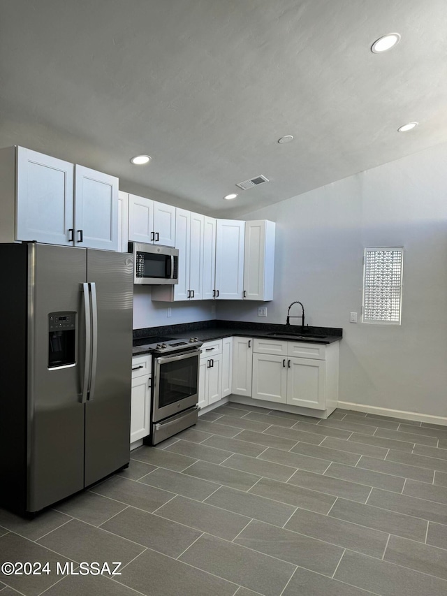 kitchen featuring sink, white cabinets, tile patterned flooring, and stainless steel appliances