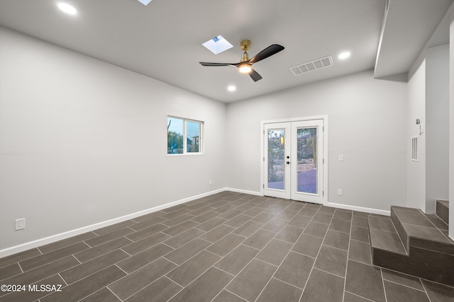 spare room with a skylight, french doors, and ceiling fan